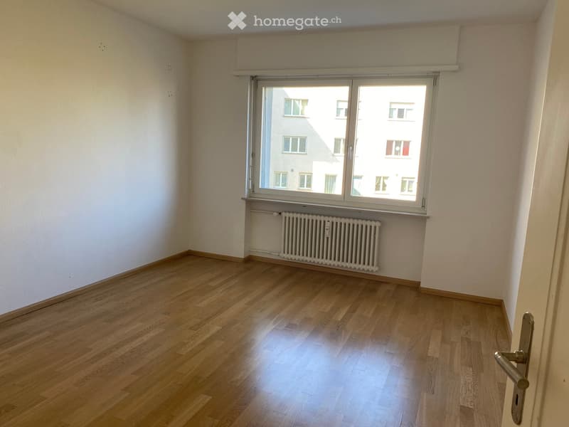 empty room, wooden floor, white walls, large window, white radiator