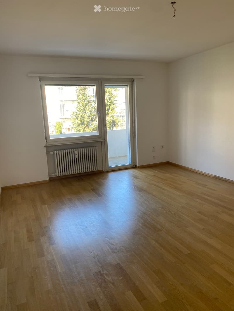 empty room, wooden floor, white walls, sliding glass door, balcony, radiator
