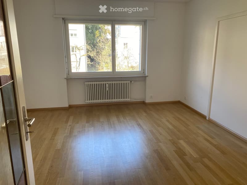 empty room, wooden floor, white walls, large window, white radiator