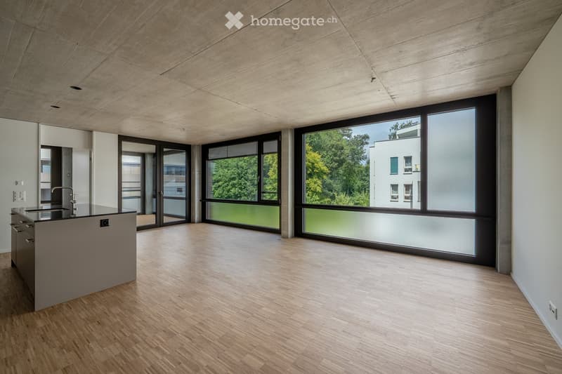 Modern kitchen with a central island, sleek wooden flooring, large windows, and a minimalist design.