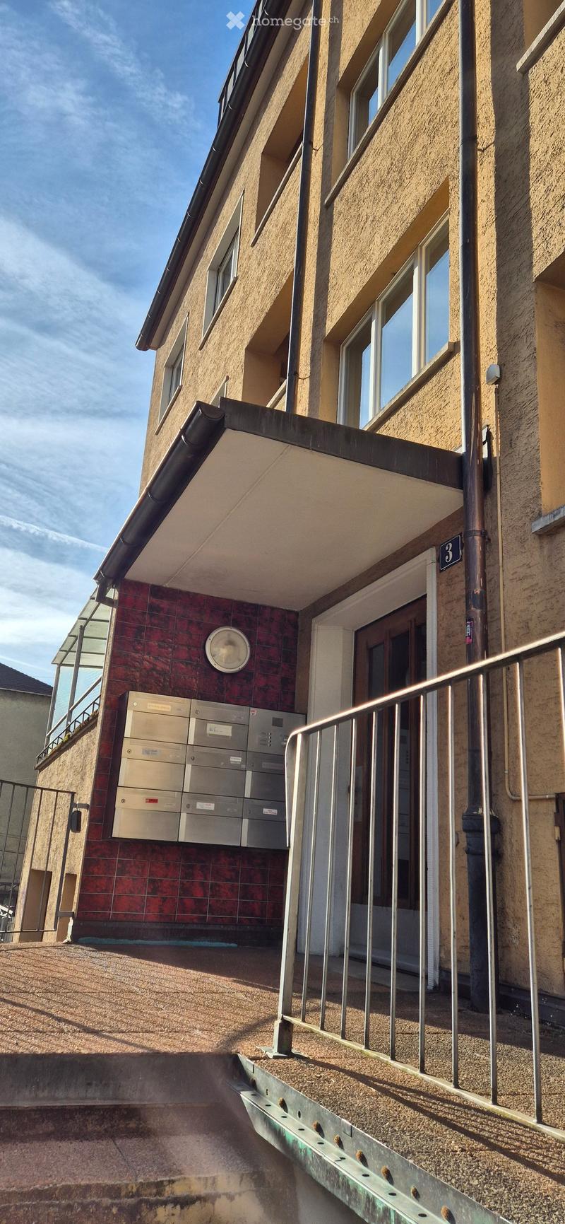 Apartment building, red brick, white windows, metal railing, mailbox, entrance