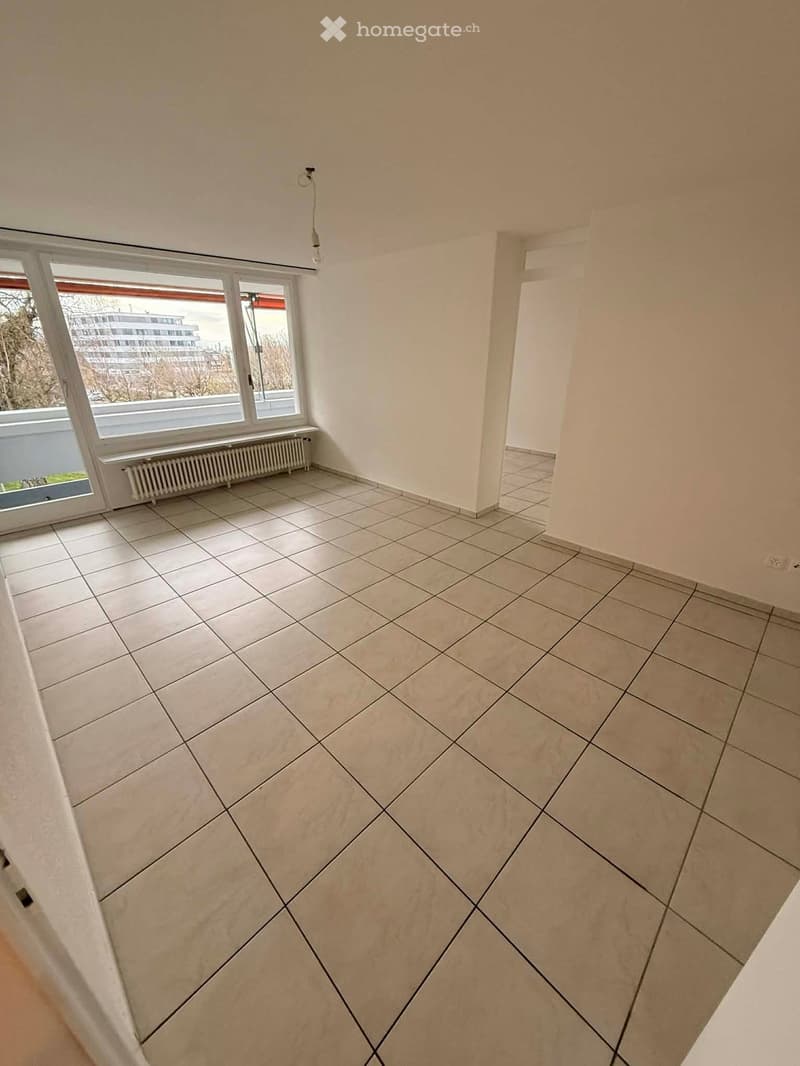 empty room, white tiles, large windows, white walls, white ceiling, white radiator, power outlet