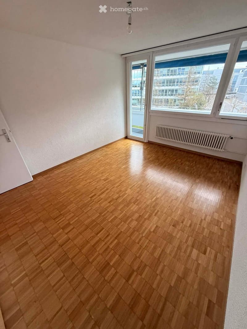 empty room, wooden floor, white walls, large windows, sliding door, radiator