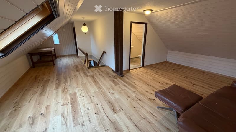 open layout with hardwood floors, couch, desk, bathroom