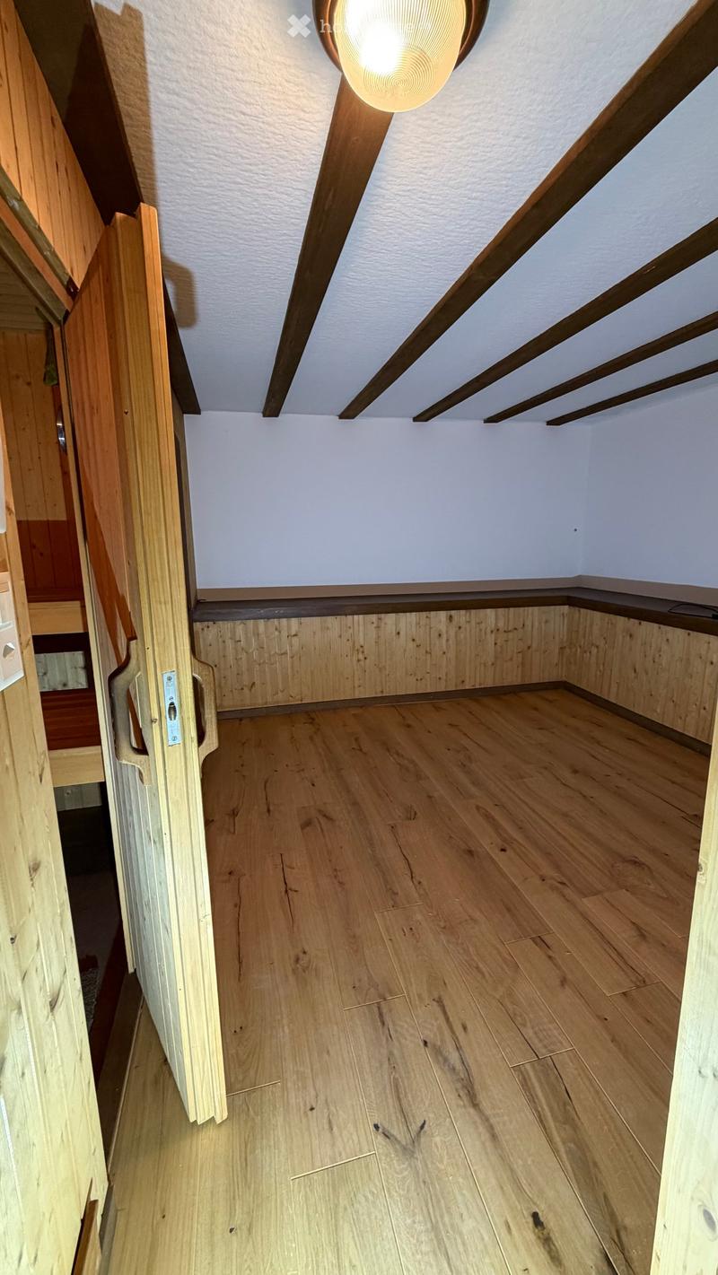 empty wooden room, wooden door, wooden walls, wooden floor, white ceiling, round light fixture