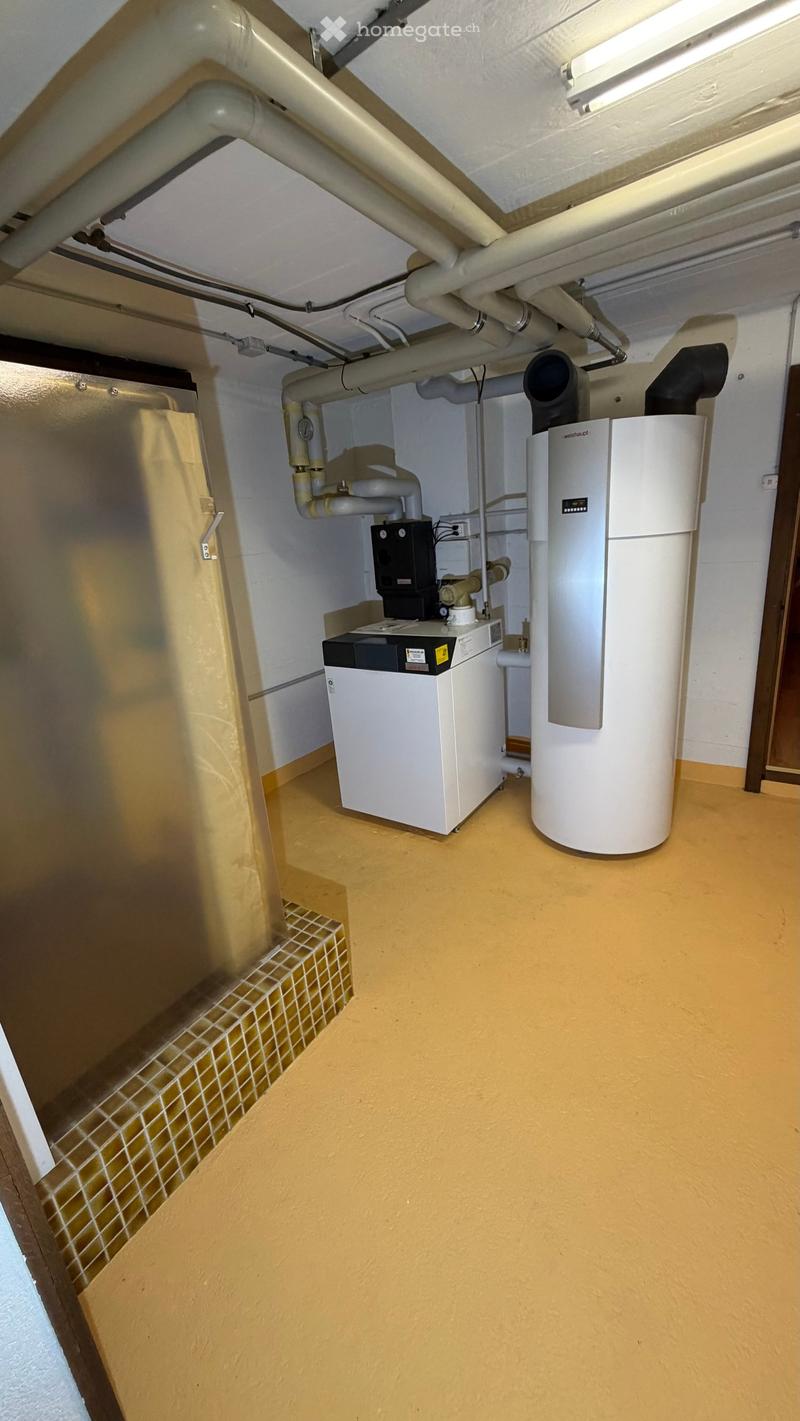 underground utility room, tiled step, white tiled floor, yellow walls, ceiling with pipes, large washing machine, water tank, water heater