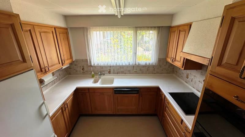 wooden cabinets, white countertops, sink, dishwasher, refrigerator, oven, window with curtains