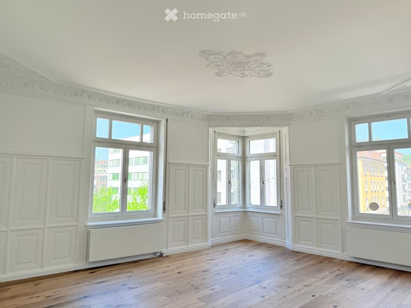 Unfurnished Room. Empty room with white walls, wooden floor, and three large windows. There are white radiators under the windows.