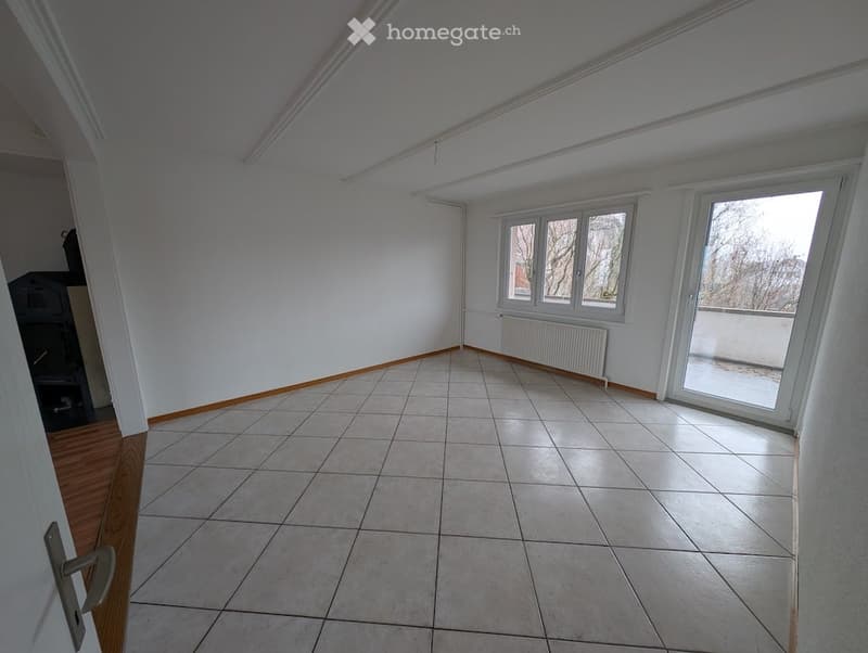 Tiled floor, white walls, large window with balcony, radiator, sliding glass door