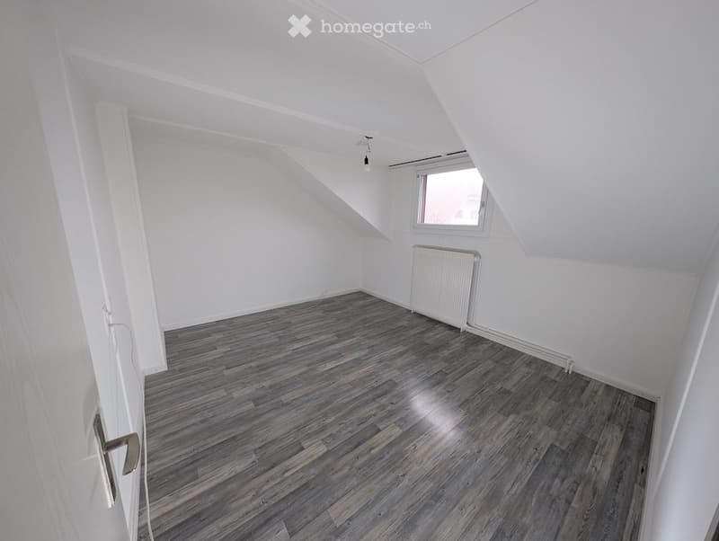 empty room, wooden floor, white walls, single window, radiator, light hanging from ceiling