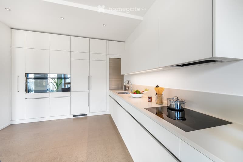 modern kitchen with white cabinets, induction stove, sink, and built-in oven