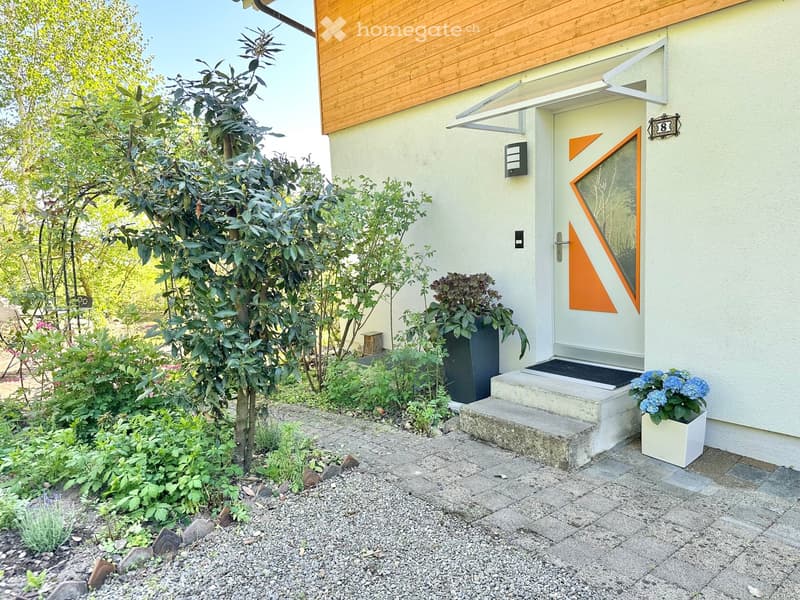 white house, wooden wall, white door, steps, plants, gravel path