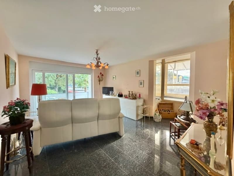 white couch, white table, white cabinet, lamp, flowers, chandelier, picture frames, windows