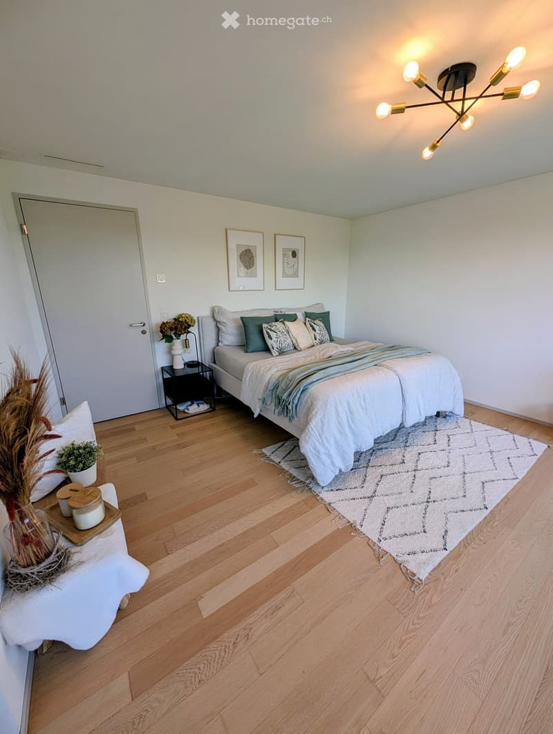 Bedroom with bed, rug, nightstand, plants, and framed pictures on the wall