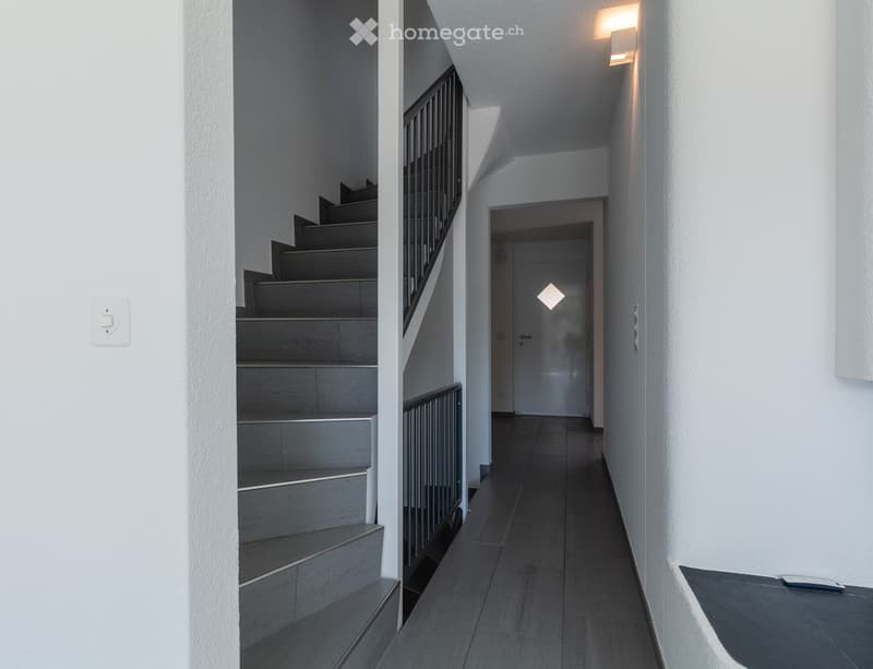 modern hallway, white walls, gray floor, black handrail, white door, light on the ceiling