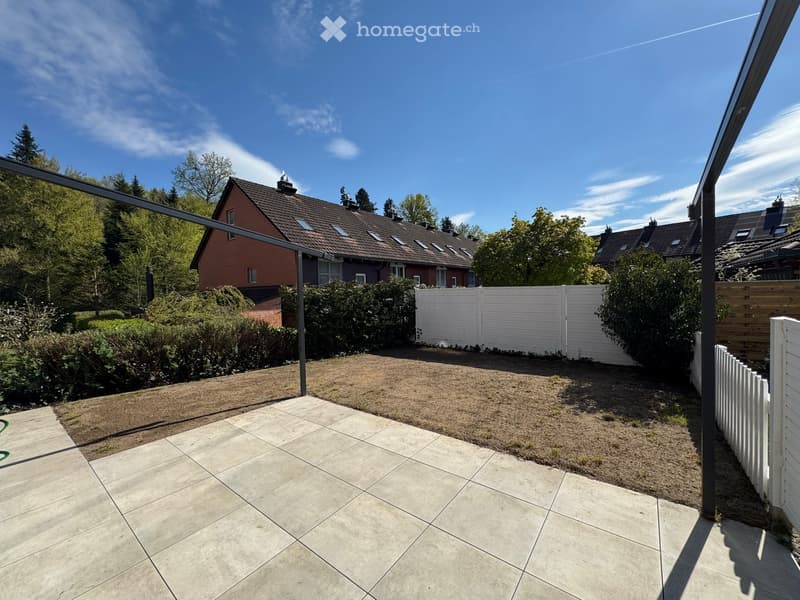 tiled patio, white fence, metal pergola, brown grass, trees, houses in the background