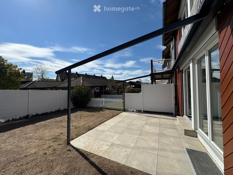 Patio with tiled floor, metal awning, white fences, and a balcony with railings