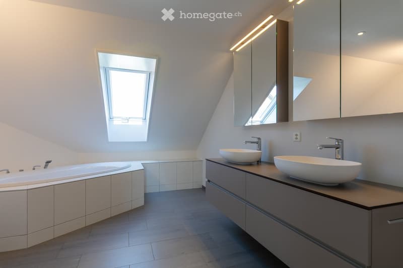 modern bathroom, bathtub, two sinks, two mirrors, skylight