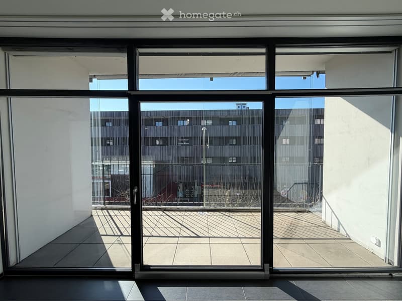 open sliding glass doors, tiled balcony, metal railing, building view