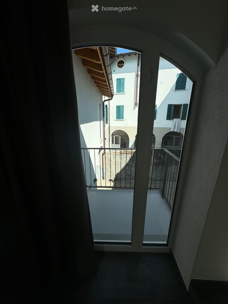 door leading to balcony, metal railing, tiled floor, white walls