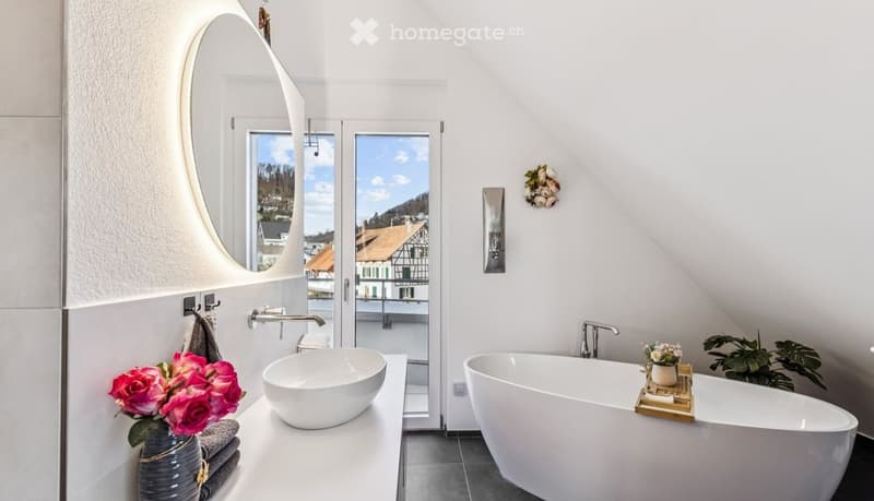 white bathtub, white sink, mirror, flowers, balcony view