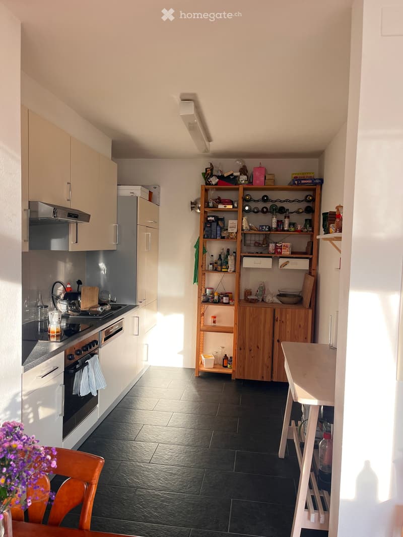 kitchen with white cabinets, black tiled floor, gas stove, oven, refrigerator, wooden shelves, white table, flower vase