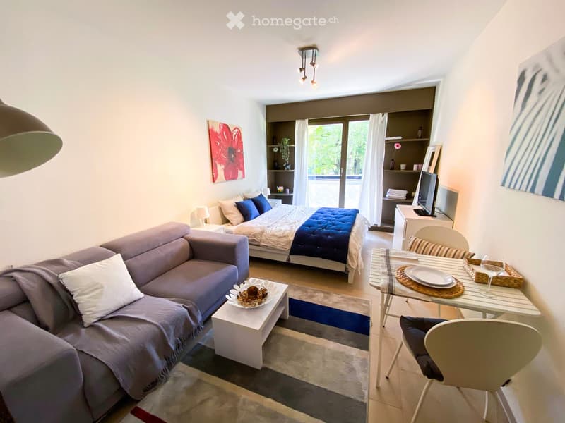 small living room with sofa, coffee table, dining table, chair, bed, bedside tables, lamp, shelves, TV, balcony