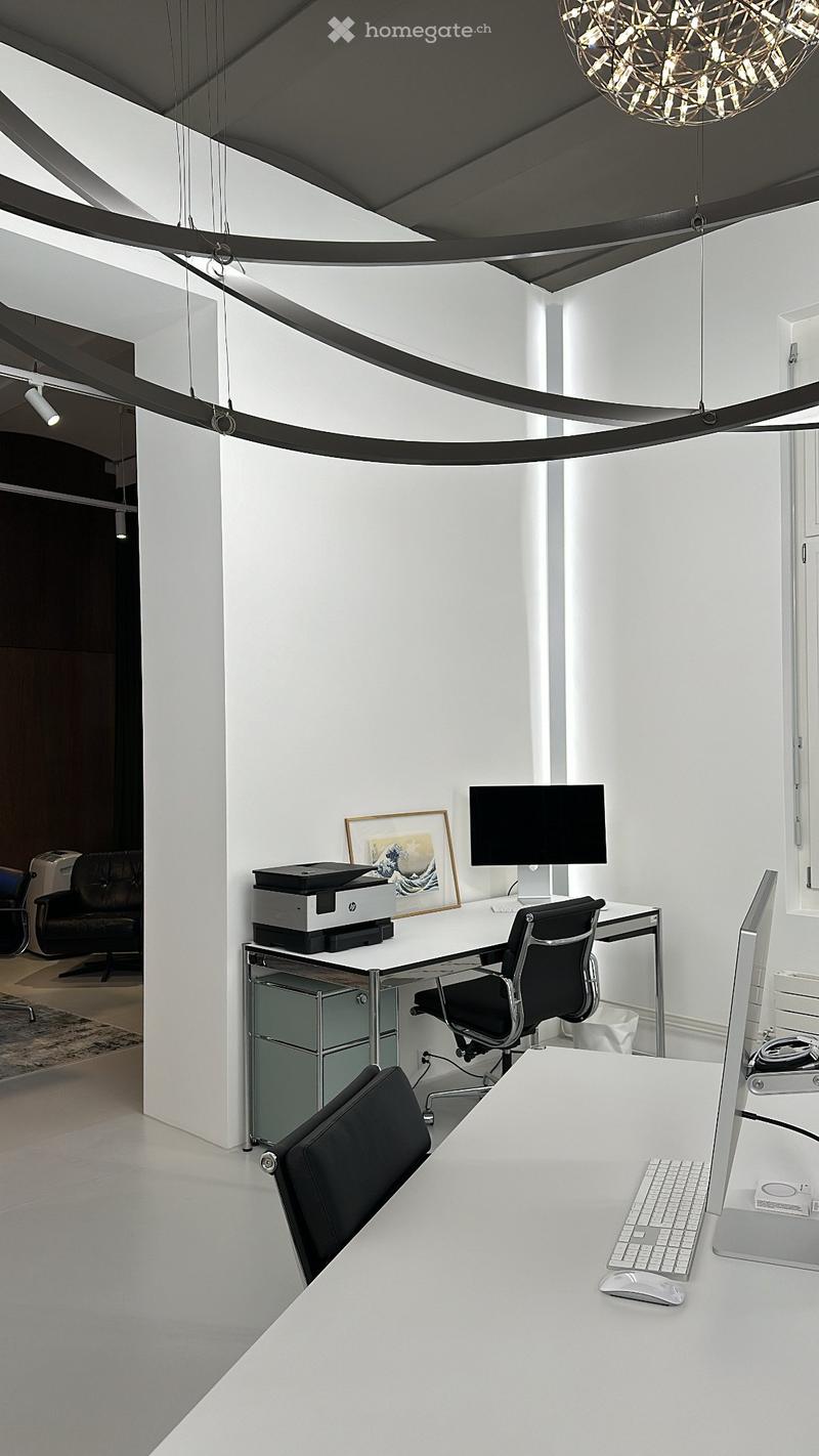 modern office with white walls, white desk, black chairs, computer, printer, picture frame, ceiling lamp