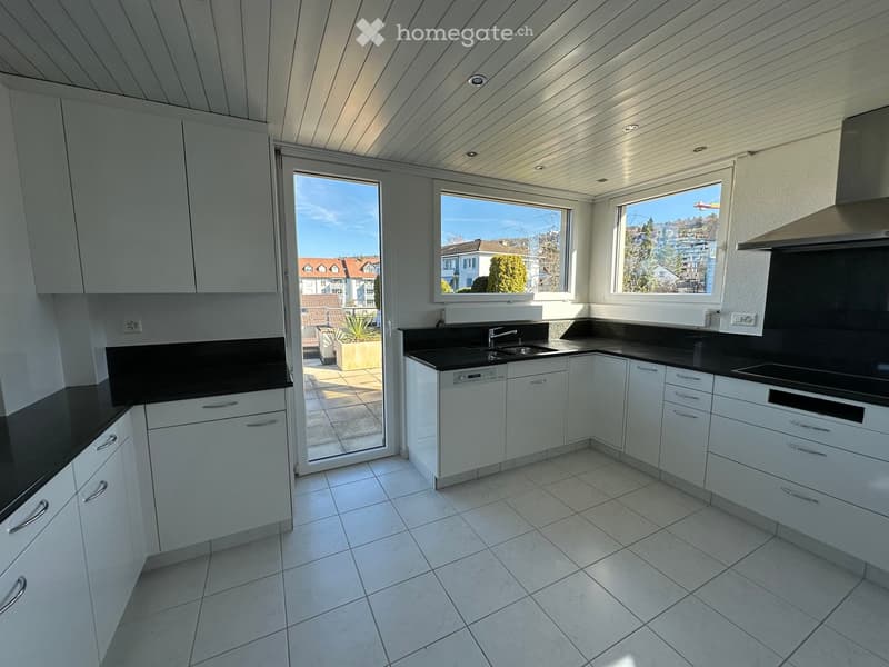 modern kitchen with white cabinets, black countertops, tiled floor, large windows, balcony