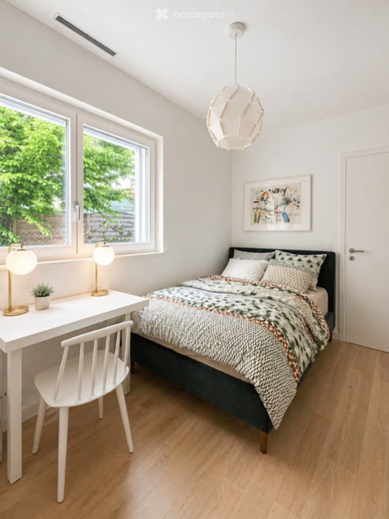 A bedroom with a bed, desk, chair, lamps, and a plant. The room has a white wall, wooden floor, and a window with a view of trees outside.