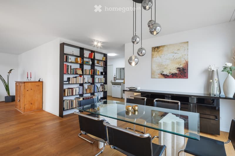 modern dining room with wooden floors, glass table, bookshelf, black modern chairs, modern lighting