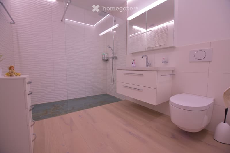 modern bathroom with white tiles, wooden floor, shower, sink, toilet, mirror, and cabinet