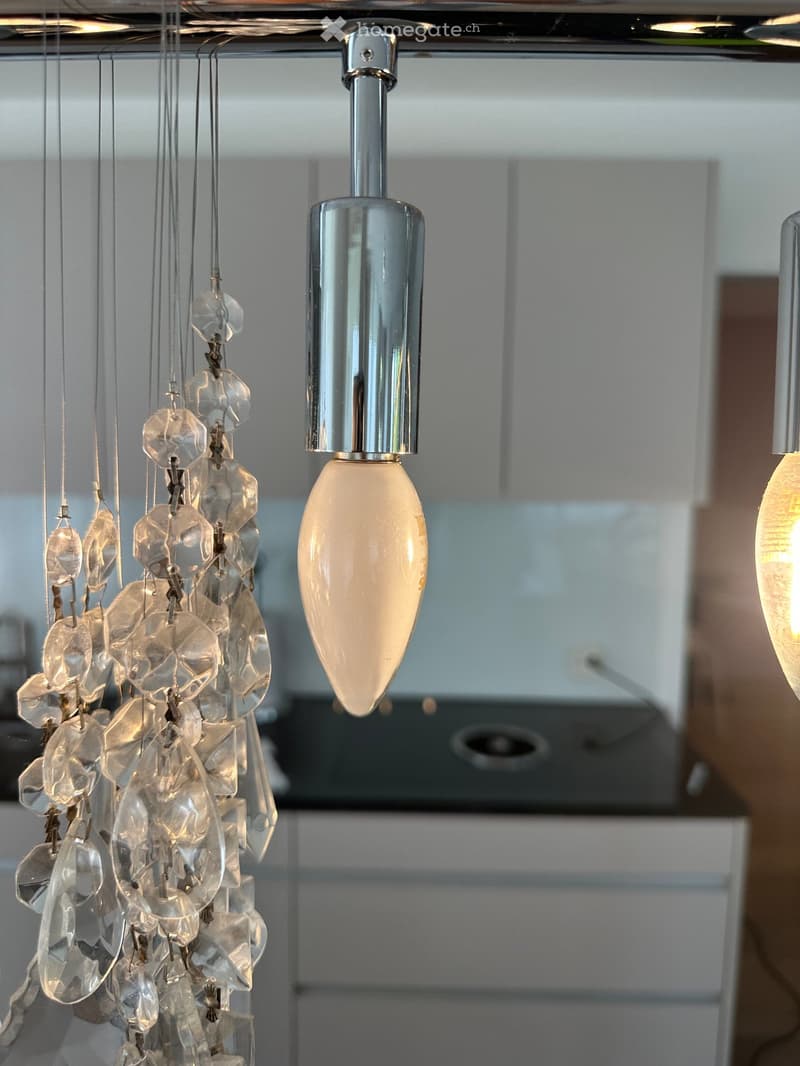 Kitchen. A modern kitchen with a crystal chandelier and a light fixture.