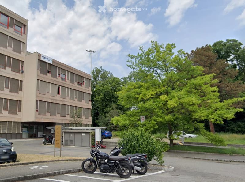 A multi-story building with a sign reading 'mercury', multiple windows, and a parking lot with motorcycles parked.