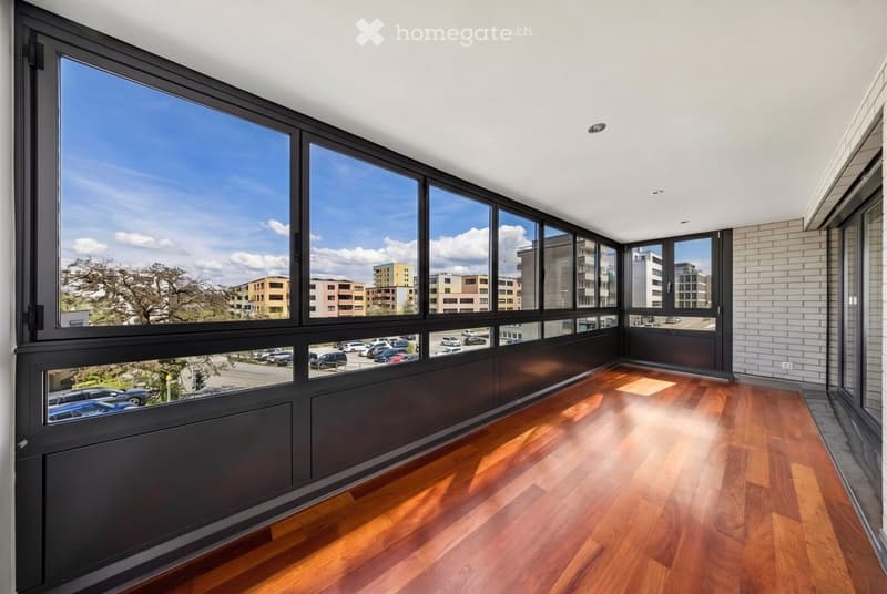 Furnished Room. Empty room with large windows, hardwood floors, and a view of the city.