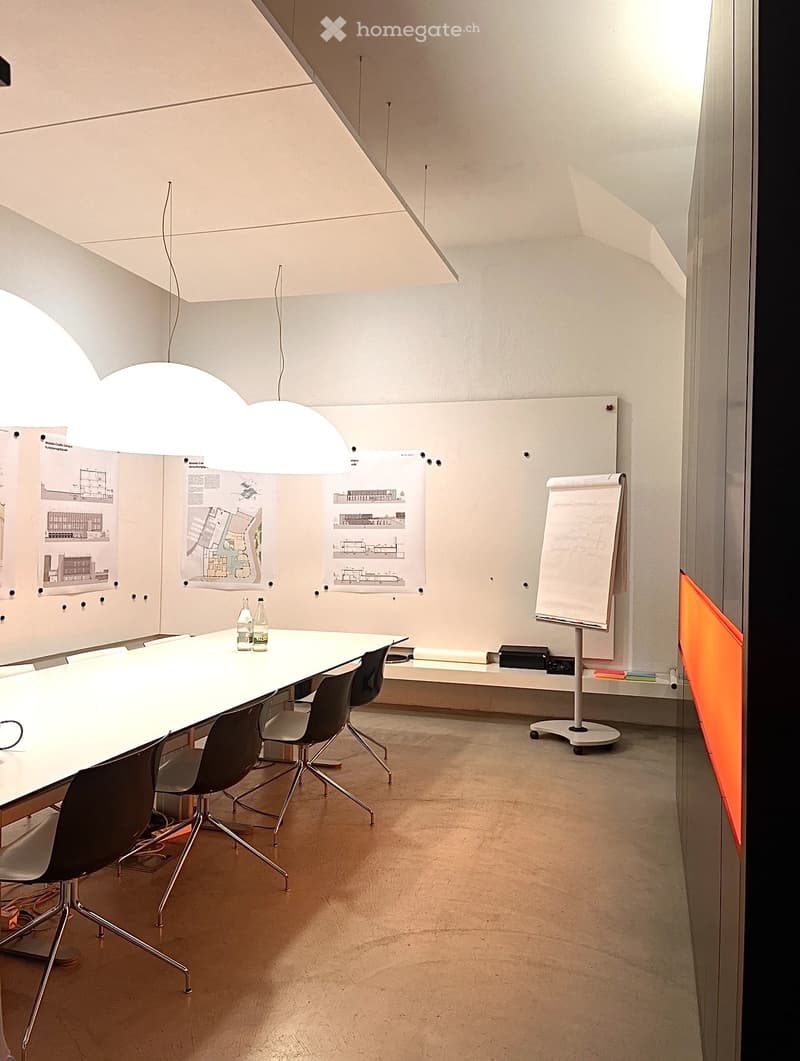 long white table, black chairs, whiteboard, white walls, lamps