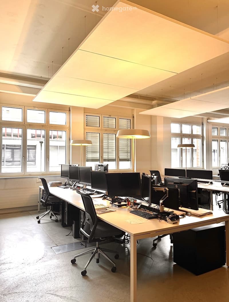 modern office with desks, chairs, monitors, keyboards, lamps, windows, beige walls, white ceiling