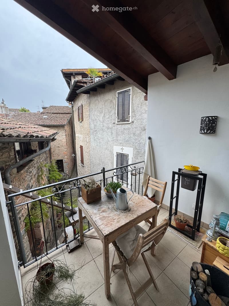 Balcony with table, chairs, plants, and a view of the street