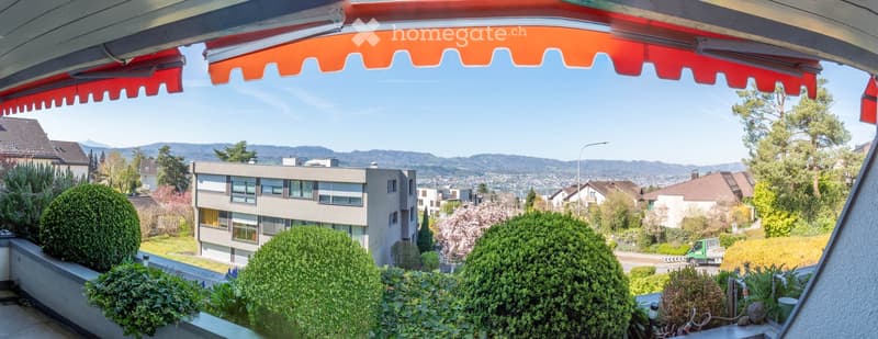 Balcony with view of the city, mountains, and greenery