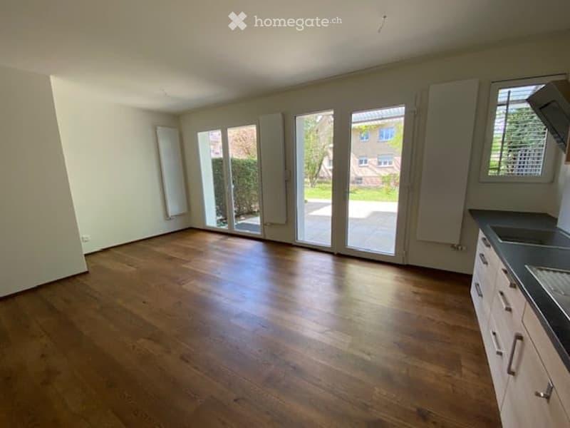 empty room, hardwood floors, sliding glass doors, white walls, kitchen area