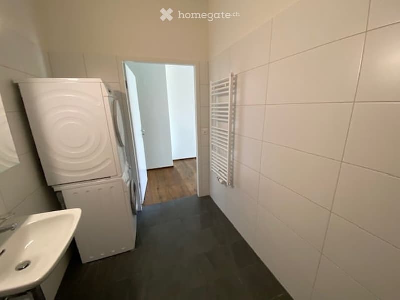 A small room with a sink, washing machine, and dryer.