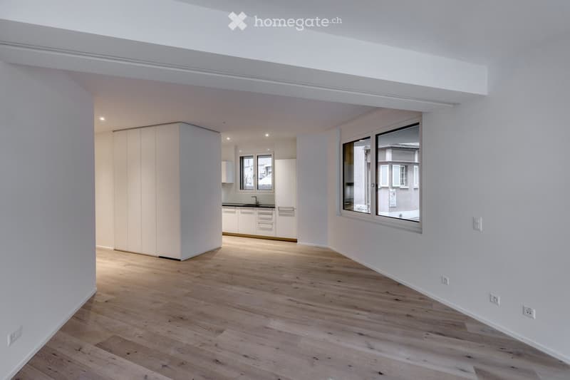 Empty room with white walls, wooden floor, and built-in cabinets. No furniture or equipment.