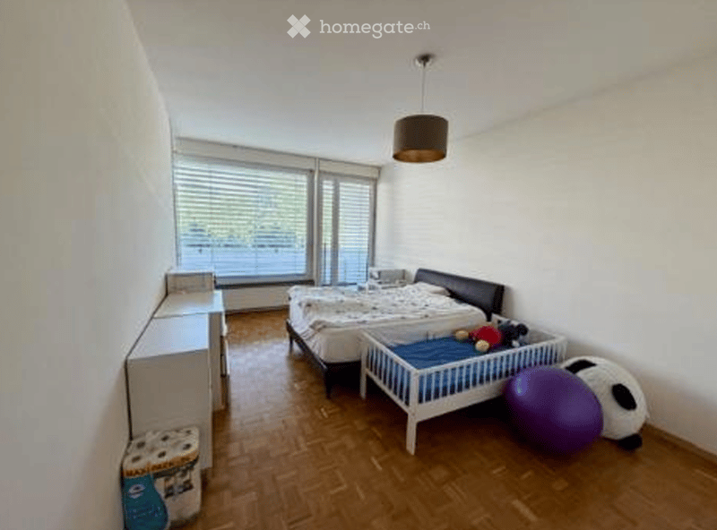 A room with a bed, crib, toys, lamp, storage box, tissue box, desk, and lamp.