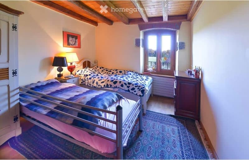 Bedroom. Bedroom with two beds, lamps, nightstands, and a rug. A picture frame and cabinet are on the wall.