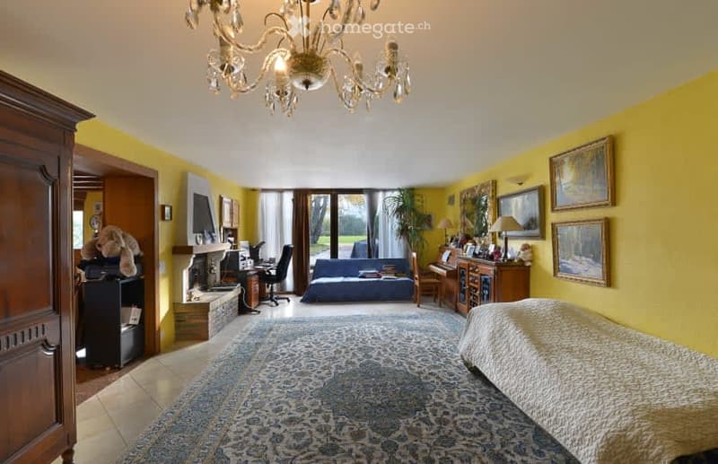 Furnished Room. A room with yellow walls, a bed, a rug, a fireplace, a desk, a chair, a couch, a lamp, a piano, a cabinet, paintings, a teddy bear, a bookshelf, and a candlestick.