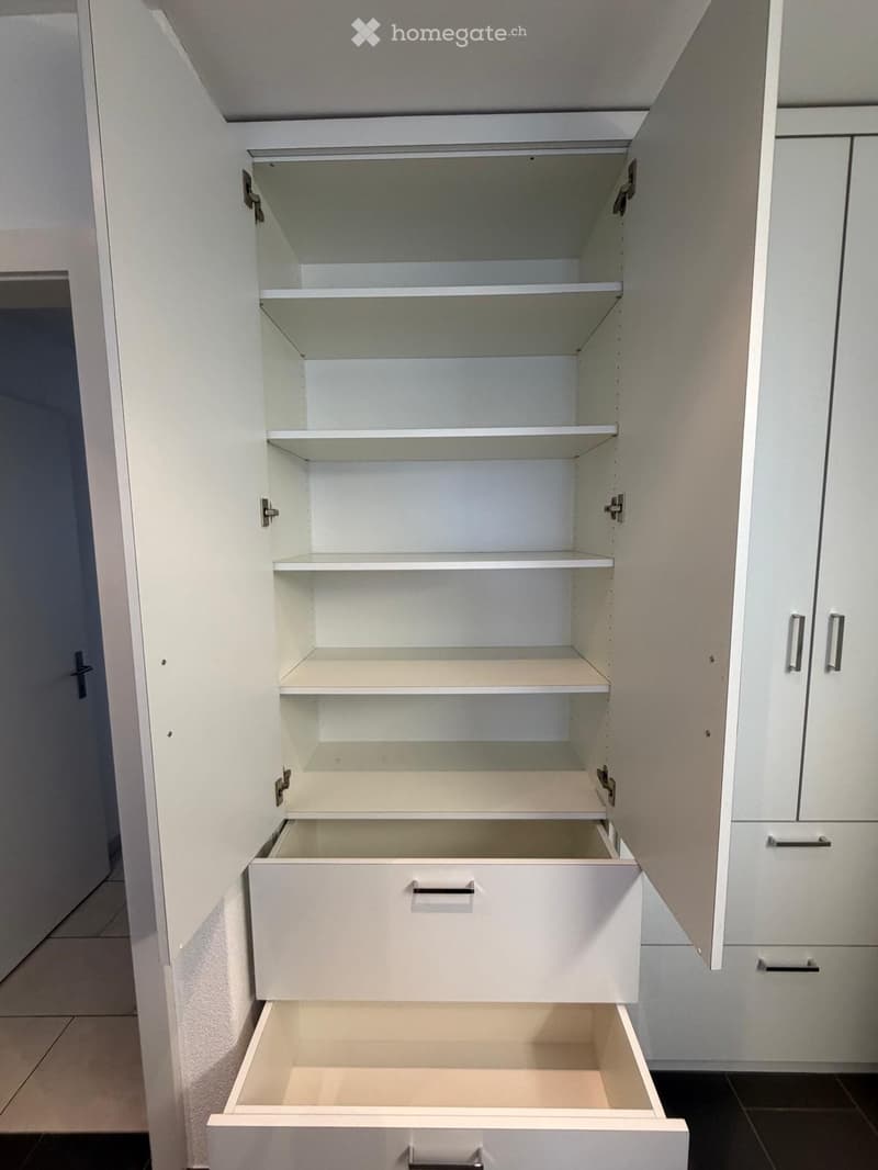 Empty white wardrobe with shelves and drawers