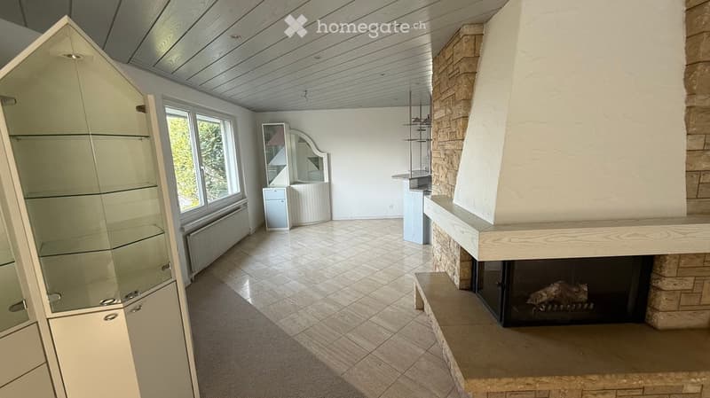 Spacious room with a fireplace, a large window, and tiled floor