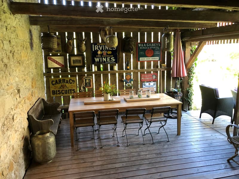 wooden deck, dining table, chairs, vintage signs, potted plant, vintage lamps, umbrella, furniture, wall decor