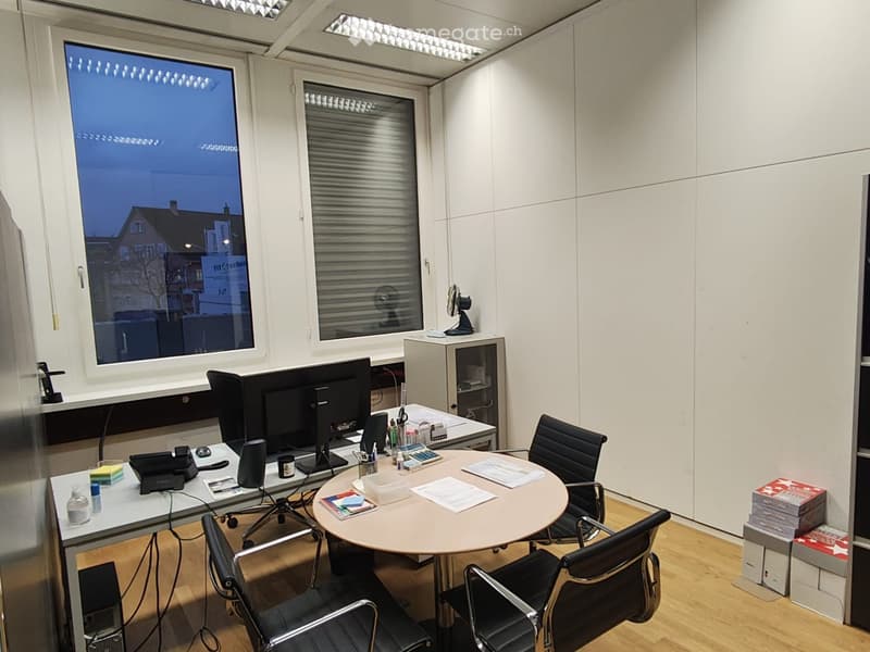 modern office, desks, computer monitors, chairs, round table, white walls, large window
