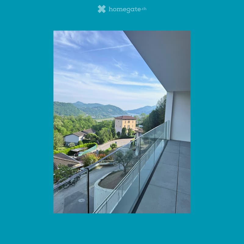 Balcony / Terrace. A balcony with a glass railing overlooking a scenic view of mountains and a road.
